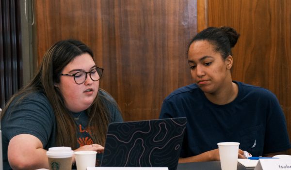 Two students looking at a laptop during class